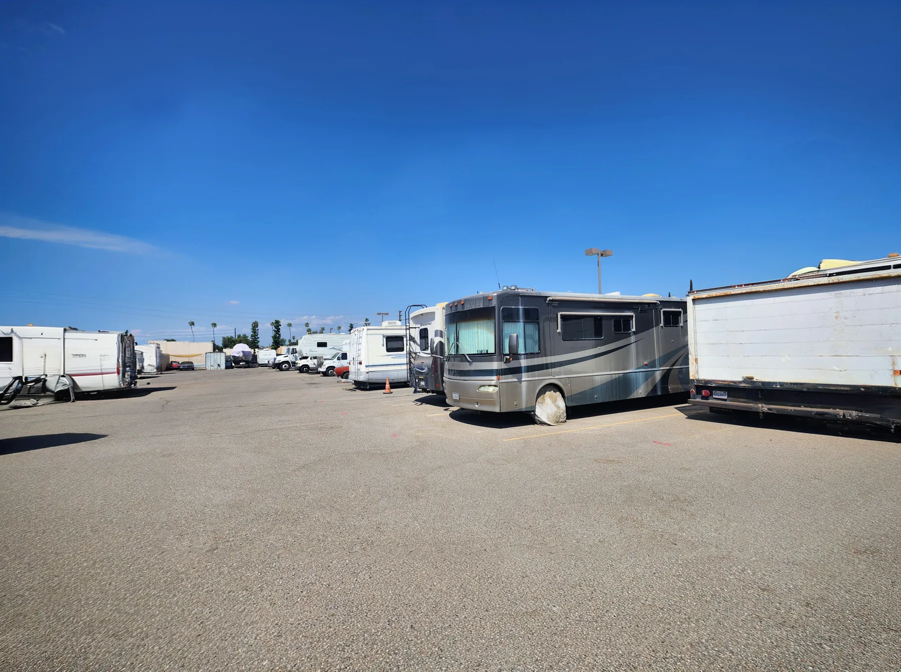 Wide view of Circle C Storage lot with RVs and motorhomes parked under a clear blue sky